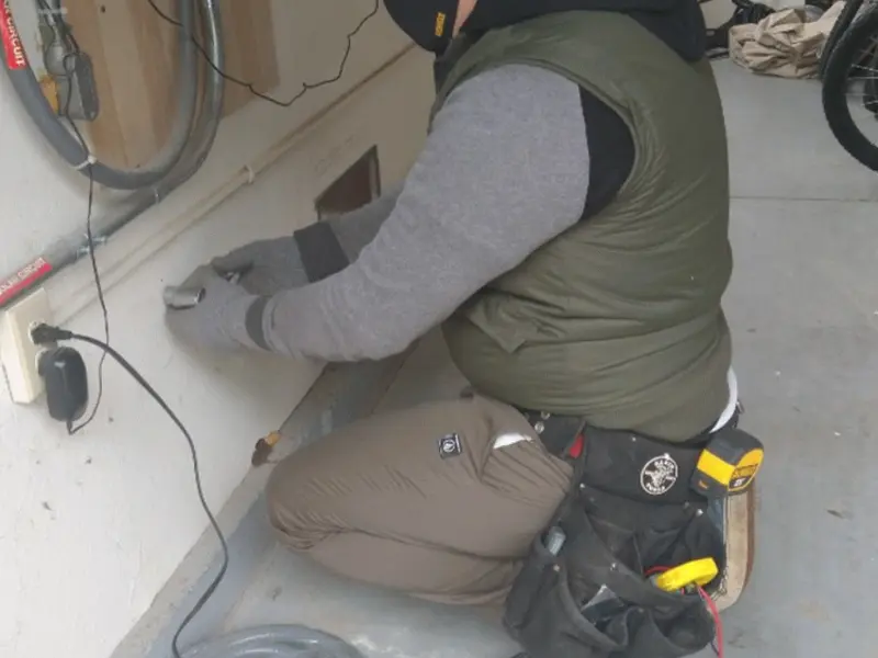 Electrician performing outlet wiring in a Crestline garage